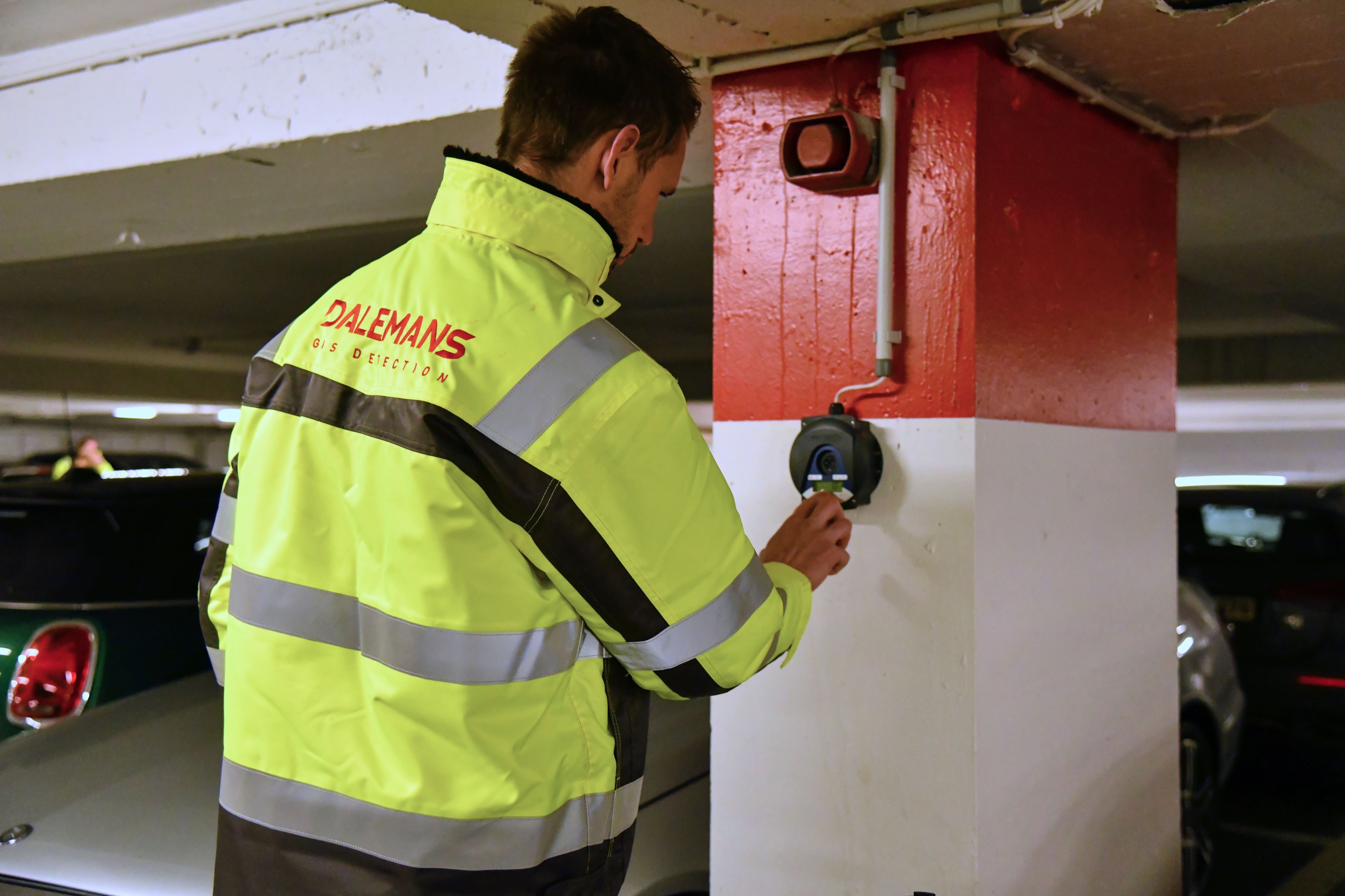 Dalemans-technicus die een gasdetectiecontrole uitvoert in een ondergrondse parkeergarage